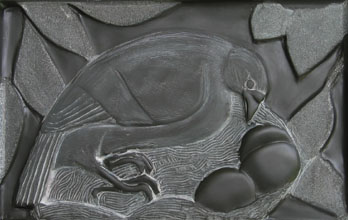 image of bird carved in slate, the birds legs are actually human hands