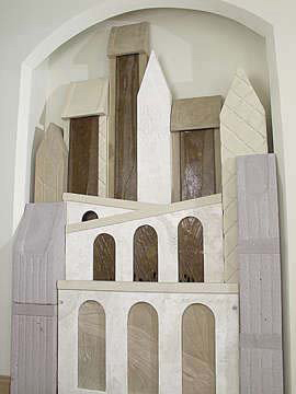 a group of architectural forms nested togehter, with arches and peaks. Water flows down the fronts of the forms. 